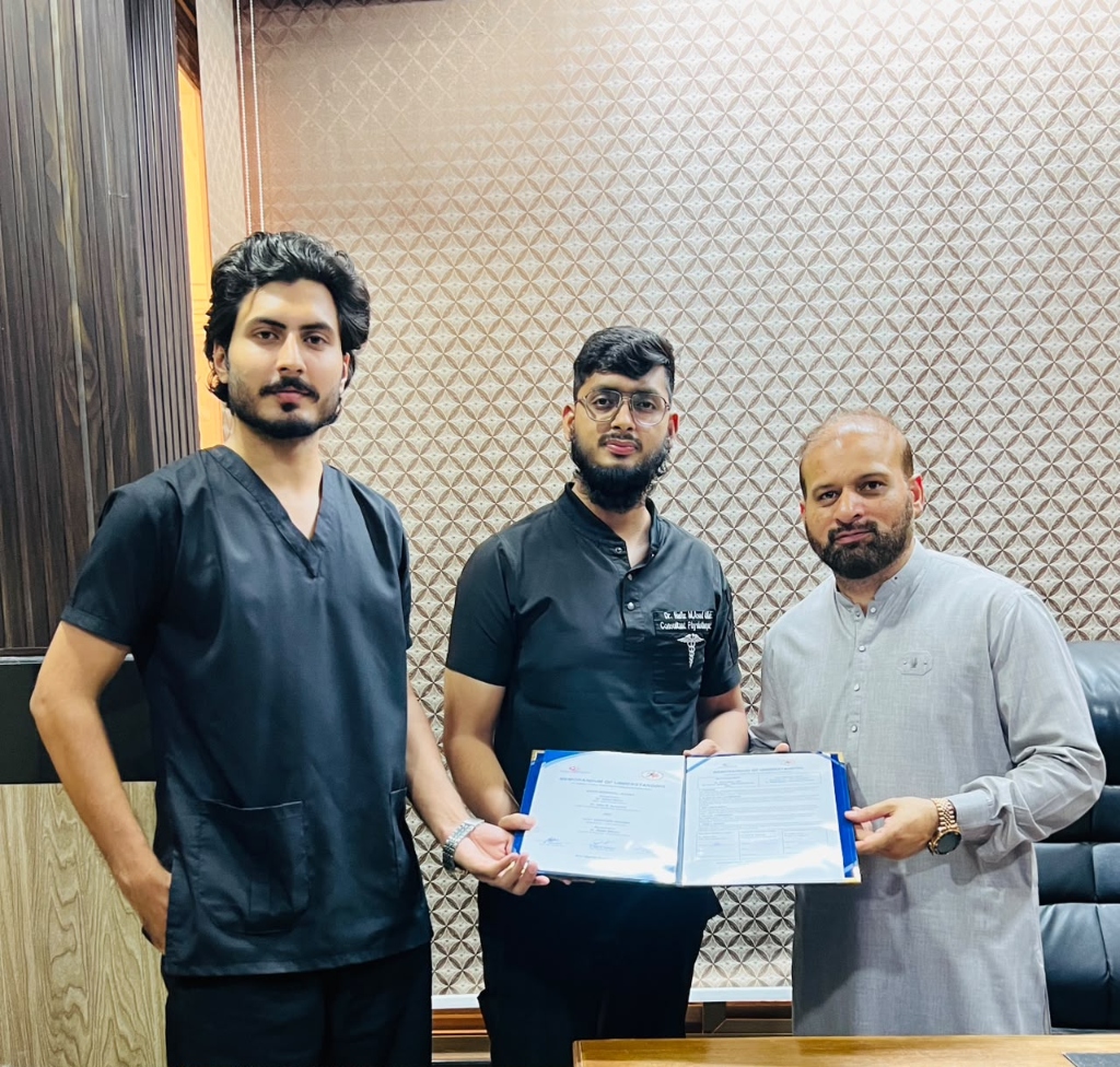 MOU signing ceremony — Dr. Hafiz M. Asadullah, Dr. Sajeel Adrees, and Mr. Adnan Munir holding the signed MOU document
